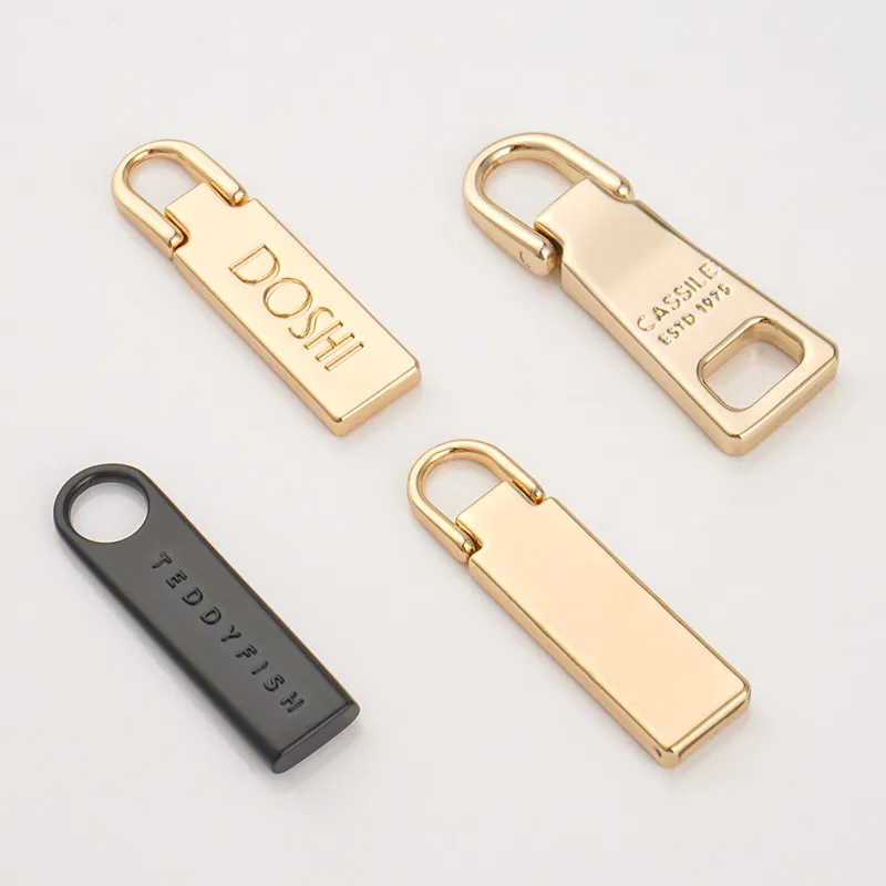 gold and black zipper puller with logo for bags